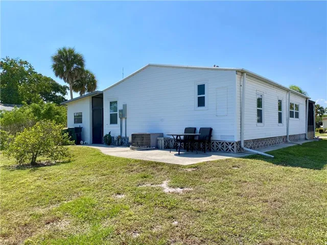 Back of property with a yard, central AC unit, and a patio area
