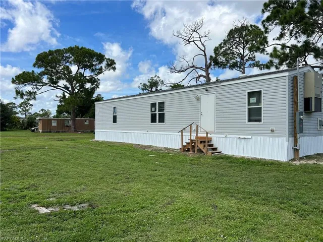 Back of house with a yard