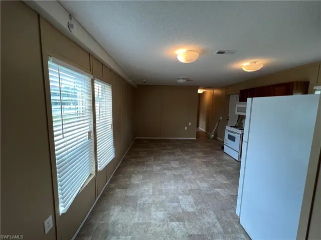 Kitchen featuring tile flooring, white appliances, and a textured ceiling
