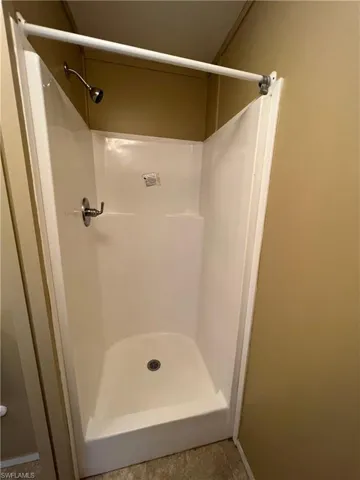 Bathroom with tile flooring and a shower