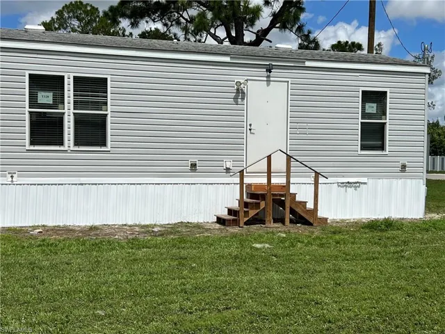 Rear view of property with a yard
