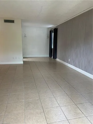 Spare room with light tile patterned flooring and a textured ceiling