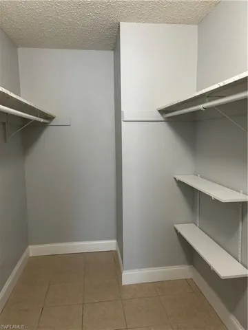 Walk in closet with light tile patterned floors