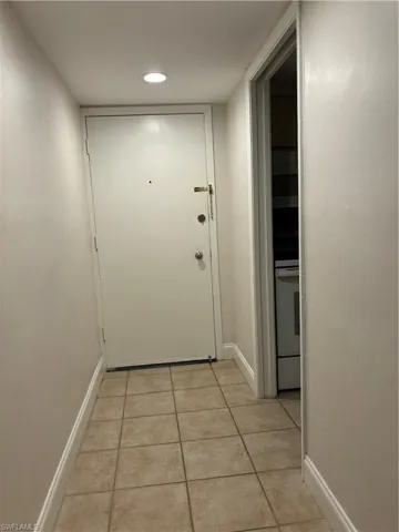 Hall featuring light tile patterned floors and recessed lighting
