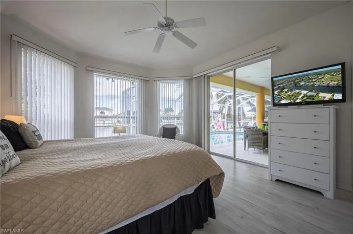 Bedroom featuring access to outside, light wood-style flooring, and ceiling fan