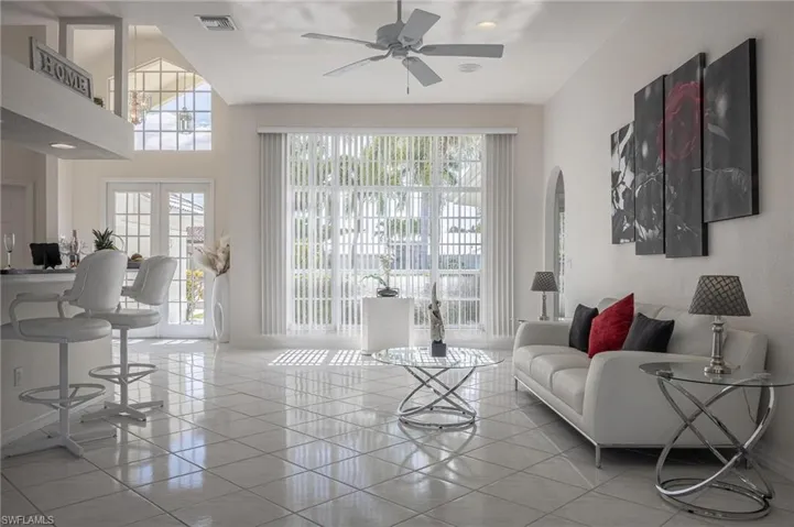 Living room with light tile patterned floors and a ceiling fan