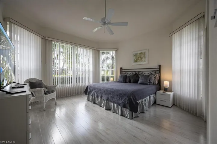 Bedroom with multiple windows, wood finished floors, and ceiling fan
