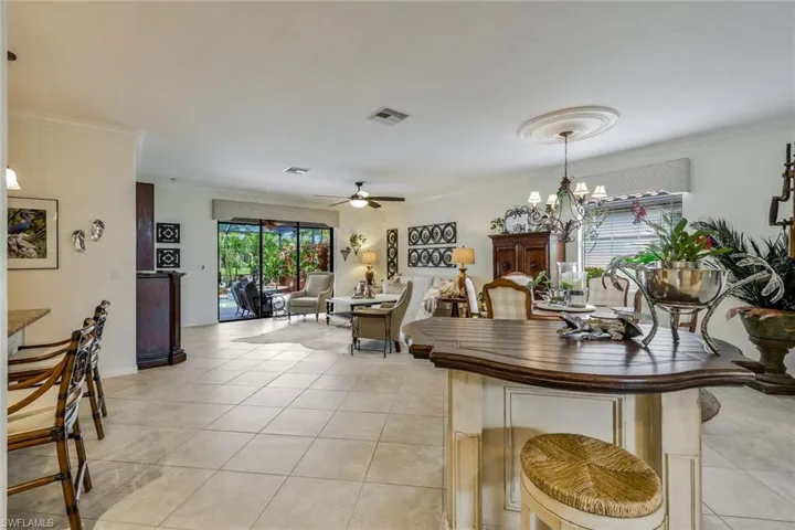 Dining room featuring crown molding, ceiling fan, light tile patterned floors, and a chandelier