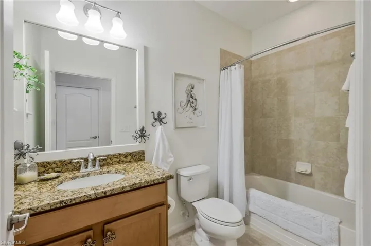 Full bathroom featuring shower / bath combo with shower curtain and vanity