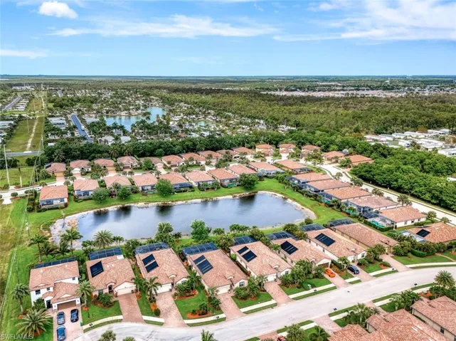Aerial view of property and surrounding area featuring nearby suburban area and a large body of water