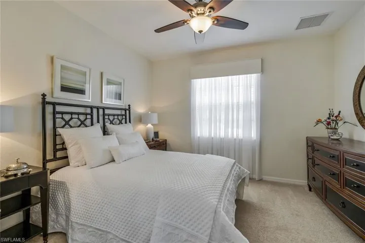 Bedroom with light carpet and a ceiling fan
