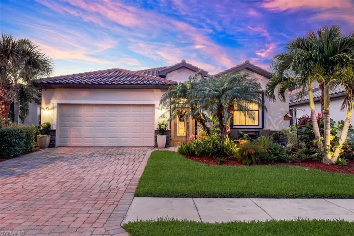 Mediterranean / spanish-style home with decorative driveway, a lawn, stucco siding, and an attached garage