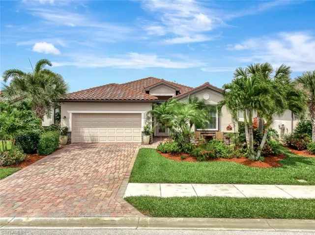 Mediterranean / spanish-style home with stucco siding, decorative driveway, an attached garage, and a front lawn