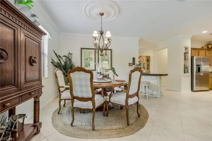 Dining room featuring ornamental molding, light tile patterned flooring, and a chandelier