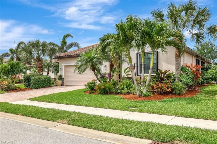Mediterranean / spanish-style home featuring an attached garage, stucco siding, driveway, and a front yard