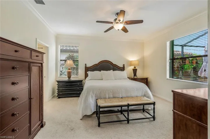 Bedroom featuring light carpet, crown molding, and a ceiling fan