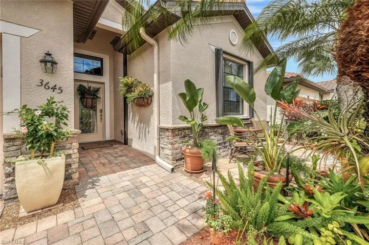 Doorway to property featuring stucco siding, a patio area, and stone siding