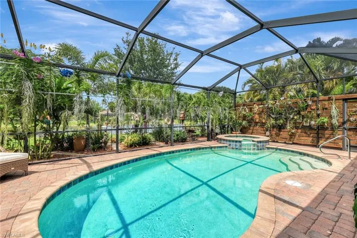 View of swimming pool featuring a pool with connected hot tub, a lanai, a sunroom, and a patio