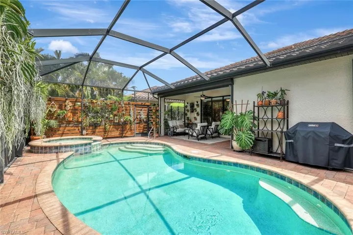View of pool featuring grilling area, a sunroom, glass enclosure, a patio, and ceiling fan