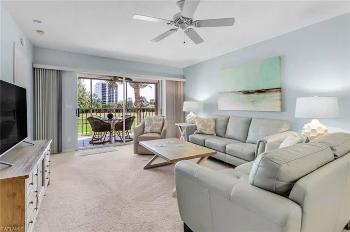 Living area featuring a ceiling fan and light carpet