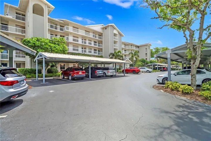 View of front of building featuring covered and uncovered parking