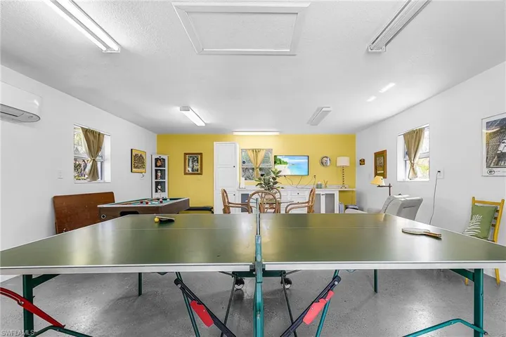 Recreation room featuring a textured ceiling and attic access