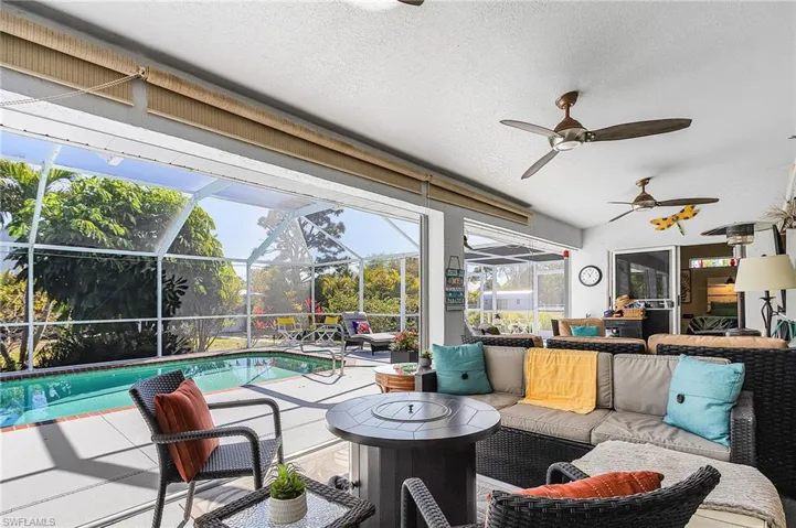 View of patio / terrace with an outdoor living space, an outdoor pool, a lanai, a sunroom, and ceiling fan