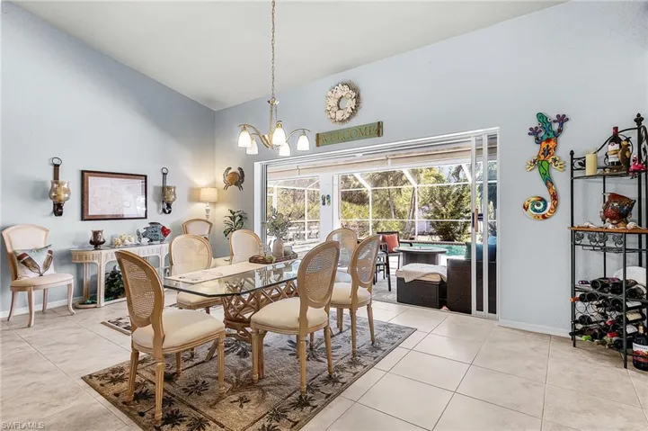 Dining space with hanging lights, vaulted ceiling, and light tile patterned floors