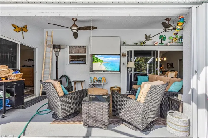 View of patio featuring ceiling fan and a sunroom