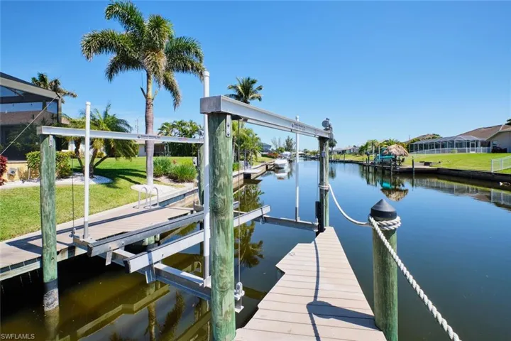View of dock with a lawn, a water view, and boat lift