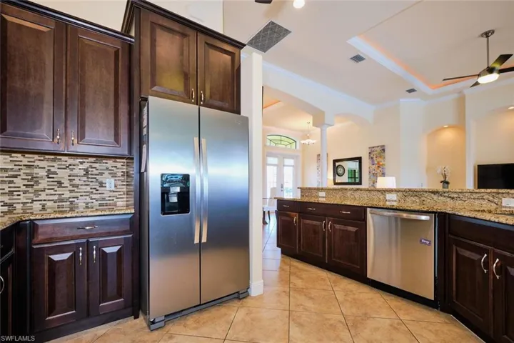 Kitchen with visible vents, a ceiling fan, tasteful backsplash, stainless steel appliances, and arched walkways