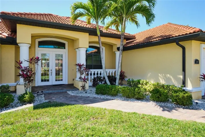 Entrance to property with a tiled roof, french doors, and stucco siding