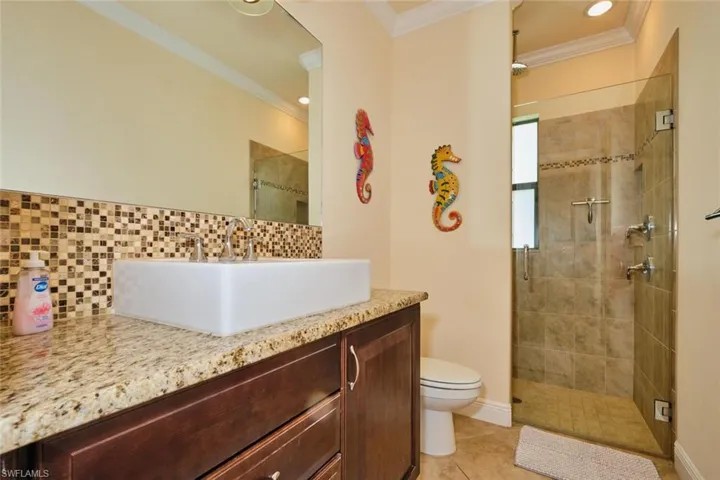 Bathroom with a stall shower, vanity, and ornamental molding