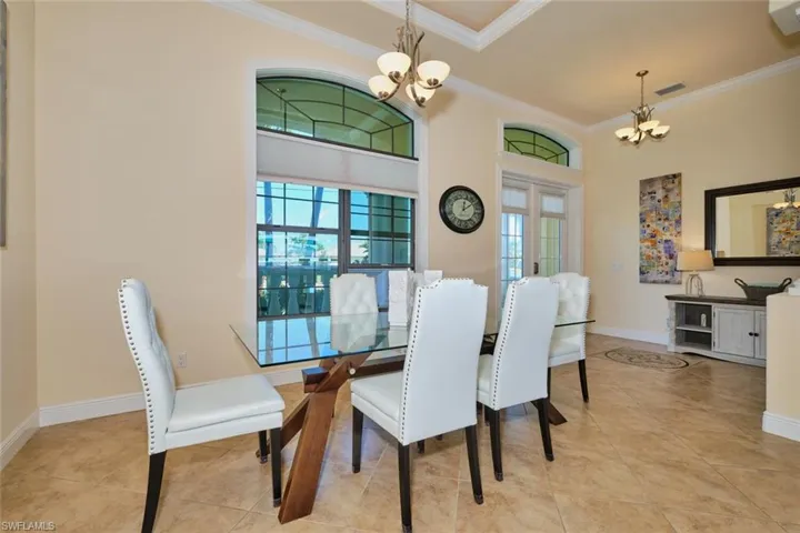 Dining room featuring visible vents, crown molding, and an inviting chandelier