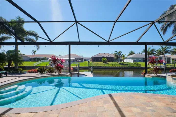 Pool featuring a lanai, a residential view, a patio, and a water view