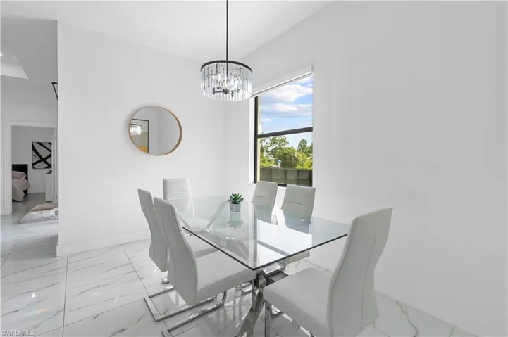 Bright dining area featuring a crystal chandelier and large window