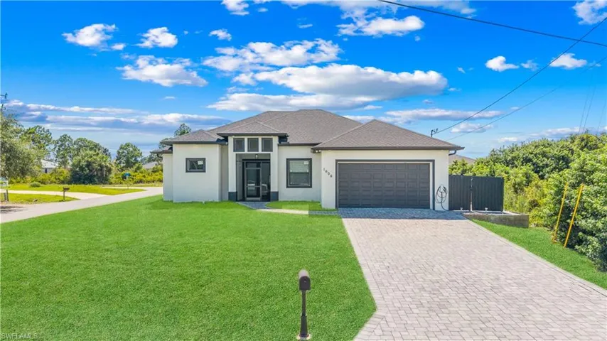 Contemporary exterior featuring a light stucco finish, dark trim, and a dark shingle roof