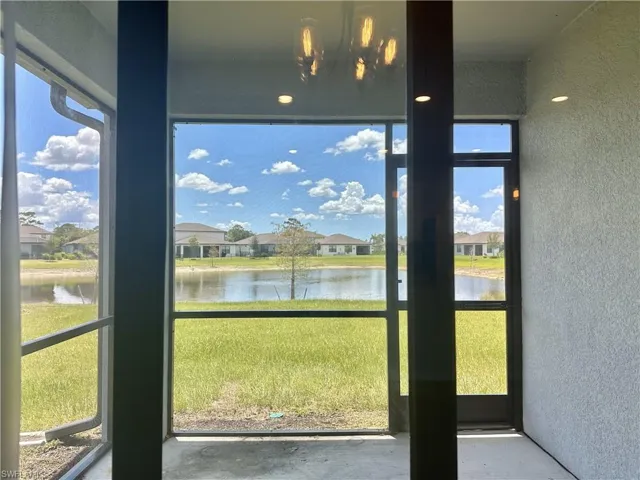 Unfurnished sunroom with a residential view and a water view