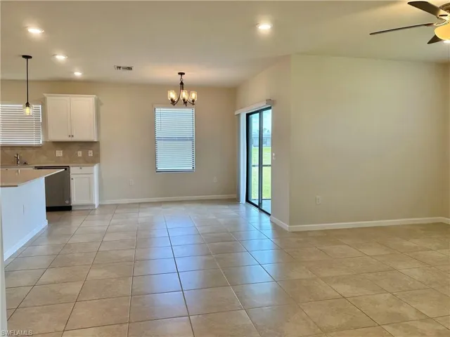 Kitchen featuring recessed lighting, a chandelier, white cabinets, backsplash, and light tile patterned floors