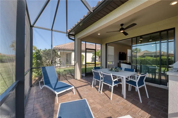 Screened outdoor patio featuring paver flooring, a ceiling fan, and sliding glass doors