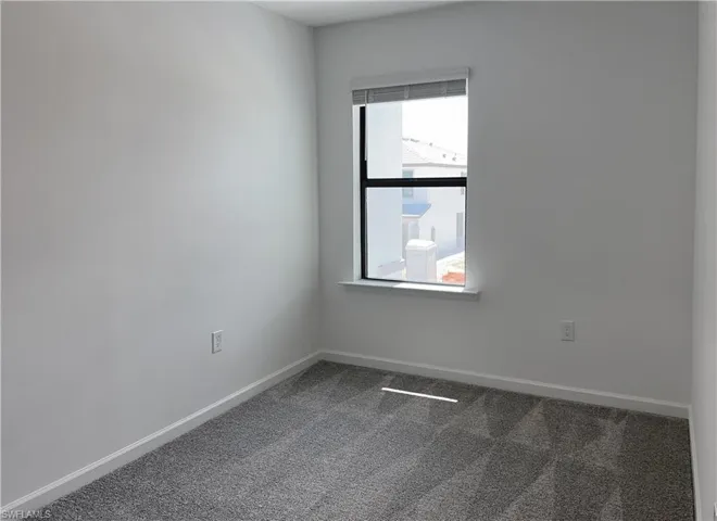 Unfurnished room with carpet flooring and baseboards