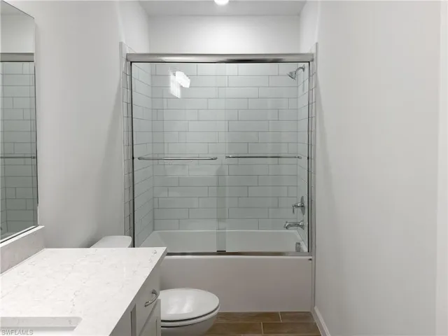 Bathroom with enclosed tub / shower combo and vanity