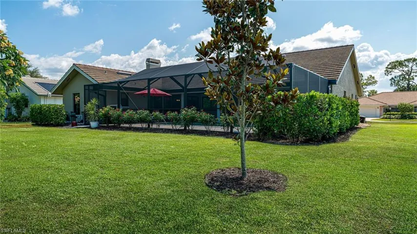 View of yard featuring, lush landscaping, screened in Pool/Lanai area