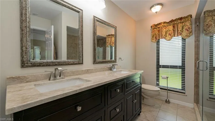 Bathroom featuring a window, new counter tops with double sink vanity,  tile floors, Large Shower