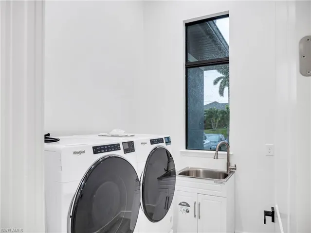 Laundry area featuring washing machine and clothes dryer and cabinet space