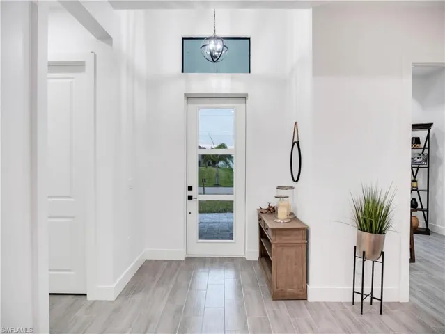 Foyer entrance featuring hanging lights and wood tiled floors