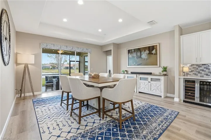 Dining room featuring wine cooler, light wood-style floors, and recessed lighting