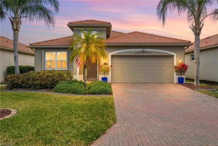 Mediterranean / spanish house with decorative driveway, stucco siding, a garage, a tile roof, and a front yard