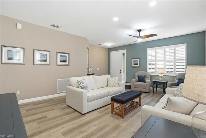 Living area featuring light wood-type flooring, a ceiling fan, and recessed lighting