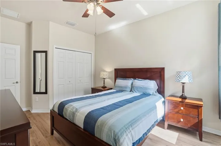 Bedroom with a closet, light wood-style flooring, and a ceiling fan